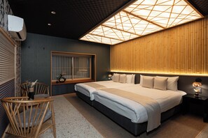 Ein modernes Schlafzimmer mit einem großen Bett, Nachttischen, einem Sessel und einem Fenster.