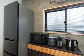 A kitchen with a refrigerator, microwave, coffee maker, and kettle on a wooden countertop. - JAPAVISTA Maverique (KONOHANA WARD)