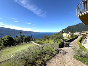 A tennis court, a stone pathway, and a view of the sea and mountains. - Marcus 706 Apartment, Residence with Pool and Lake View (Tignale)