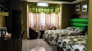 Un dormitorio con cama, escritorio, silla, una mesita y ventana con cortinas.