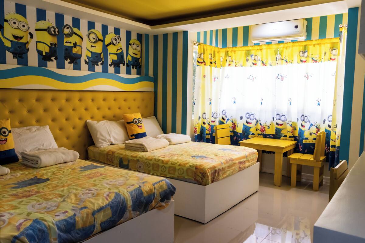 Un dormitorio con dos camas, una mesita y una silla.