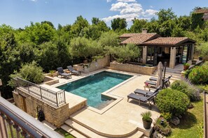 A swimming pool with lounge chairs, a covered patio, and a garden with various plants. - Villa ARtIEN, 4 bedroom house with swimming pool (Baderna)