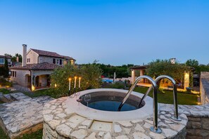 A stone pool with metal railings, surrounded by a stone deck, and a house with a tiled roof in the background. - Villa ARtIEN, 4 bedroom house with swimming pool (Baderna)