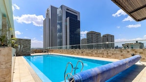 Una piscina en la azotea con vistas a un edificio del hotel Marriott al fondo.