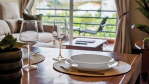 A dining table with a plate, a wine glass, and a placemat. - Our Nest - Where Light and Tranquility Meet (Caniço)