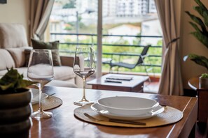 A dining table with a plate, a wine glass, and a placemat. - Our Nest - Where Light and Tranquility Meet (Caniço)