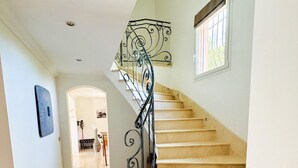 Una escalera con barandilla de hierro forjado que conduce a una plataforma.
