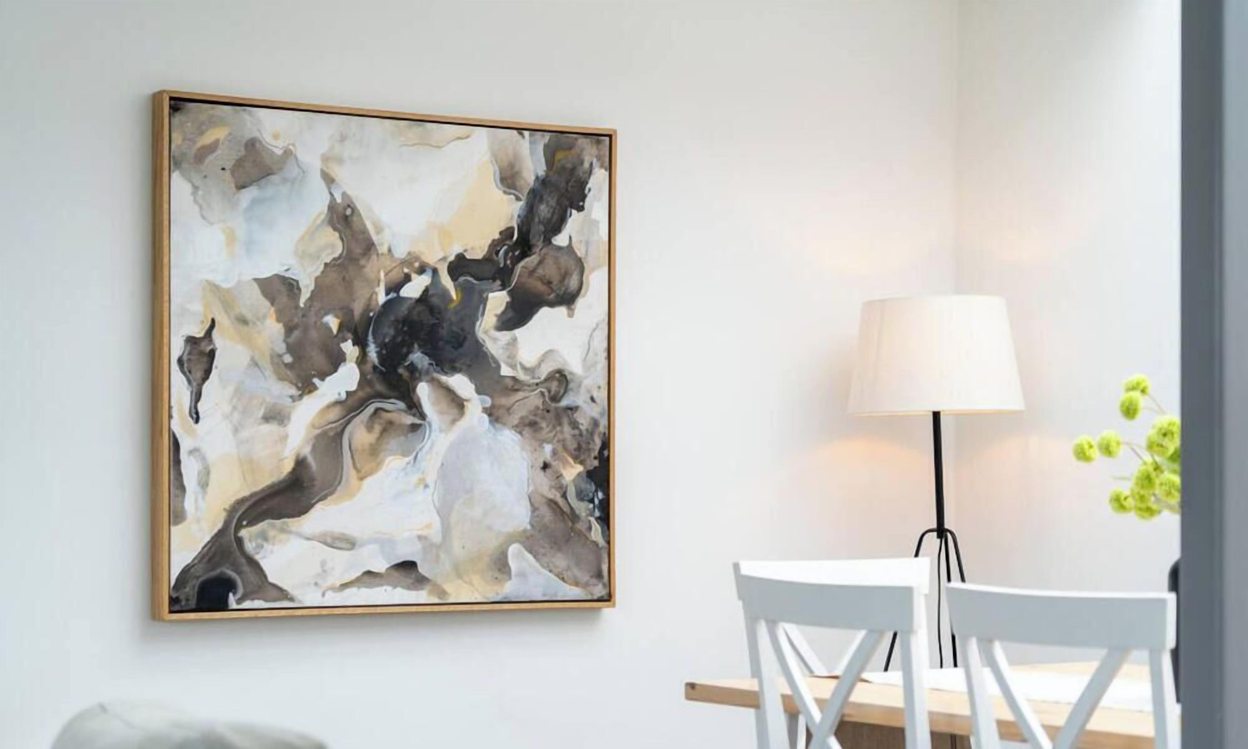A room with a large abstract painting on the wall, a white table with chairs, and a floor lamp.