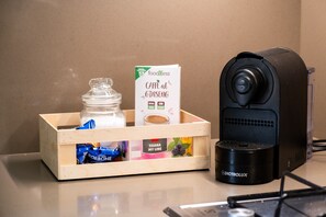 Una cafetera, un bocal de vidre, una caixa d'aliments i un tronc de fusta damunt d'una superfície.