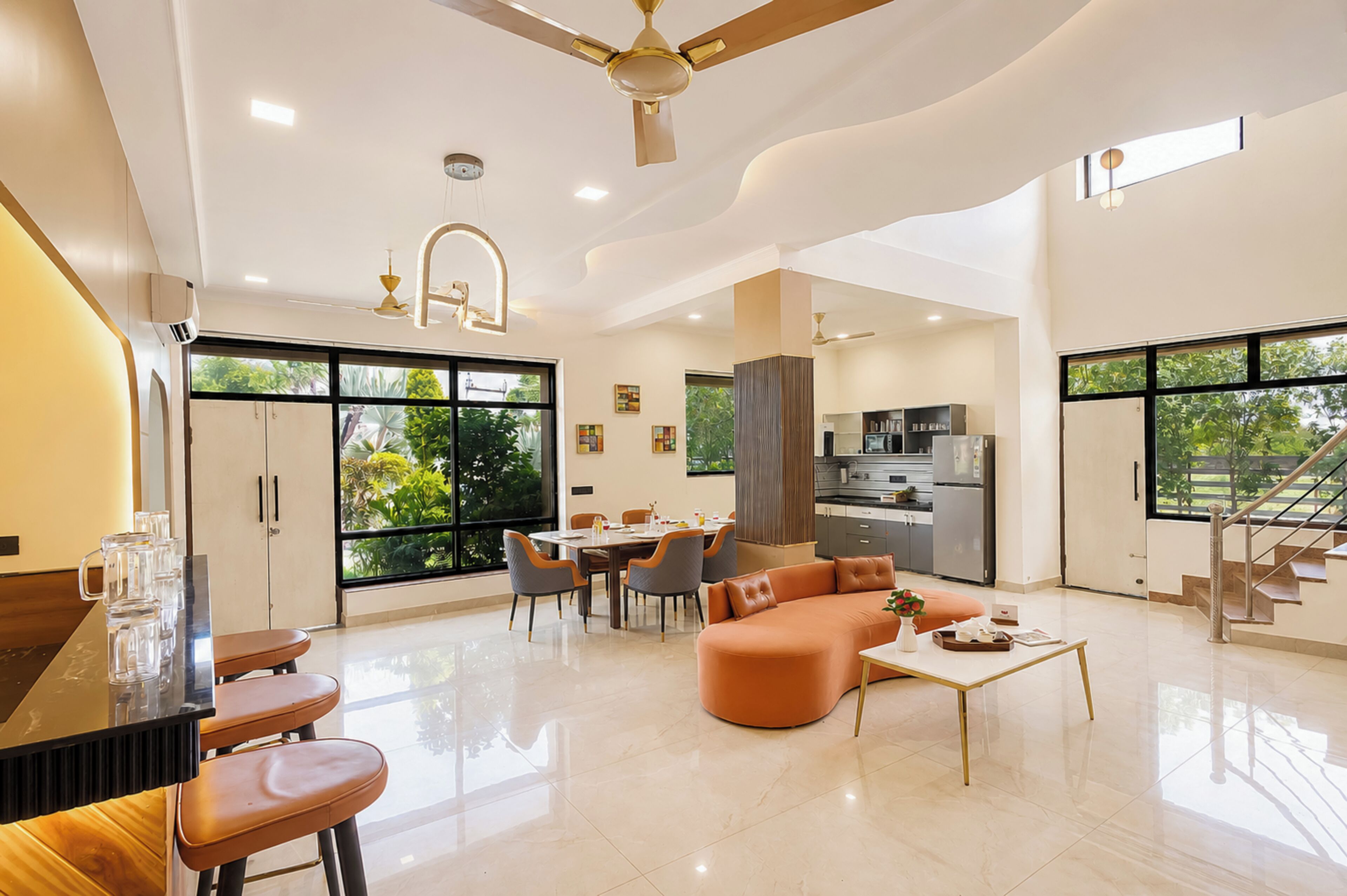 A spacious living area with a dining table, sofa, and kitchen in the background.