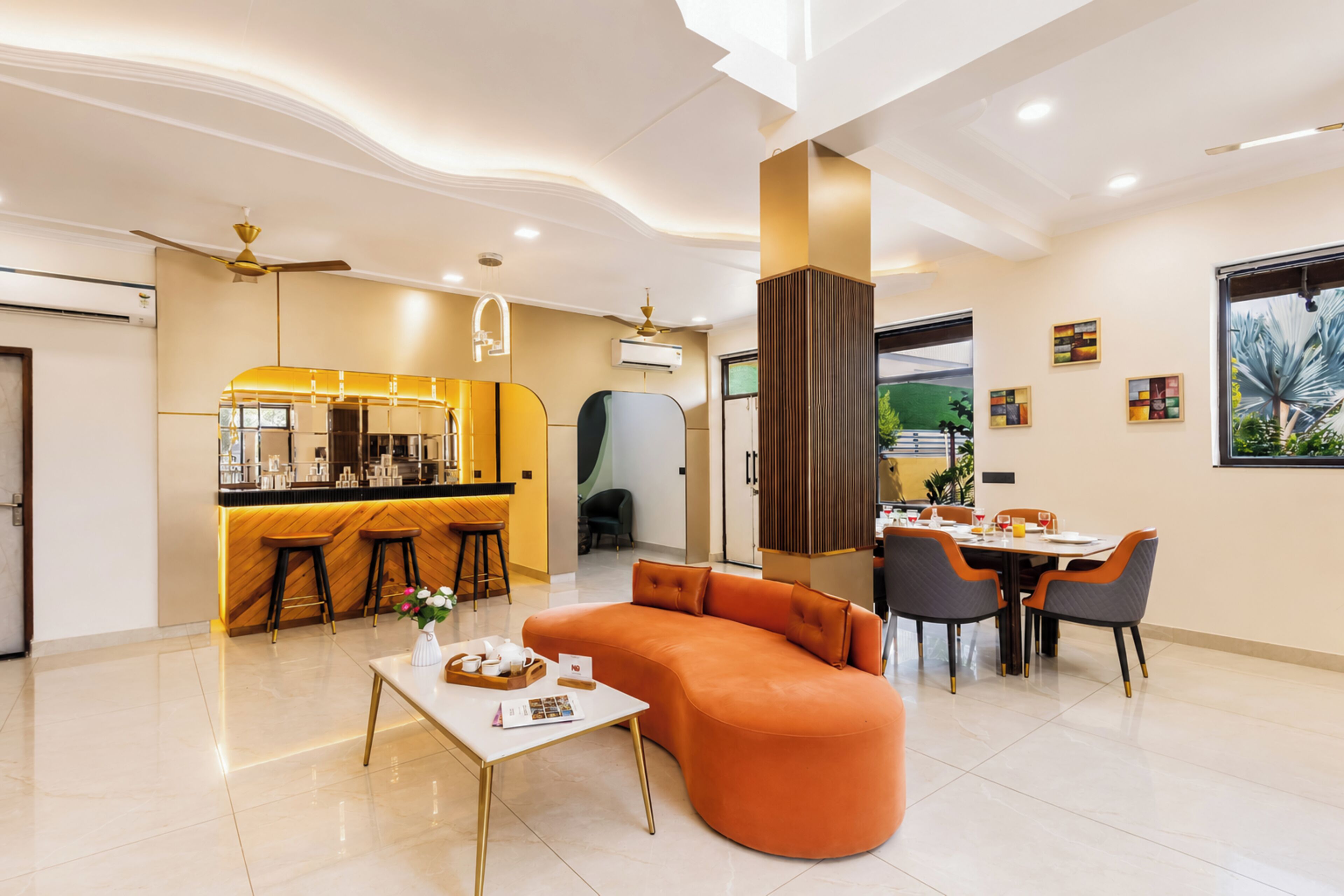 Una sala de estar moderna con sofá, mesa de comedor y zona de bar.