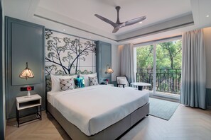 Un dormitorio moderno con una cama grande, un ventilador de techo, un balcón con cortinas y un mural en la pared.