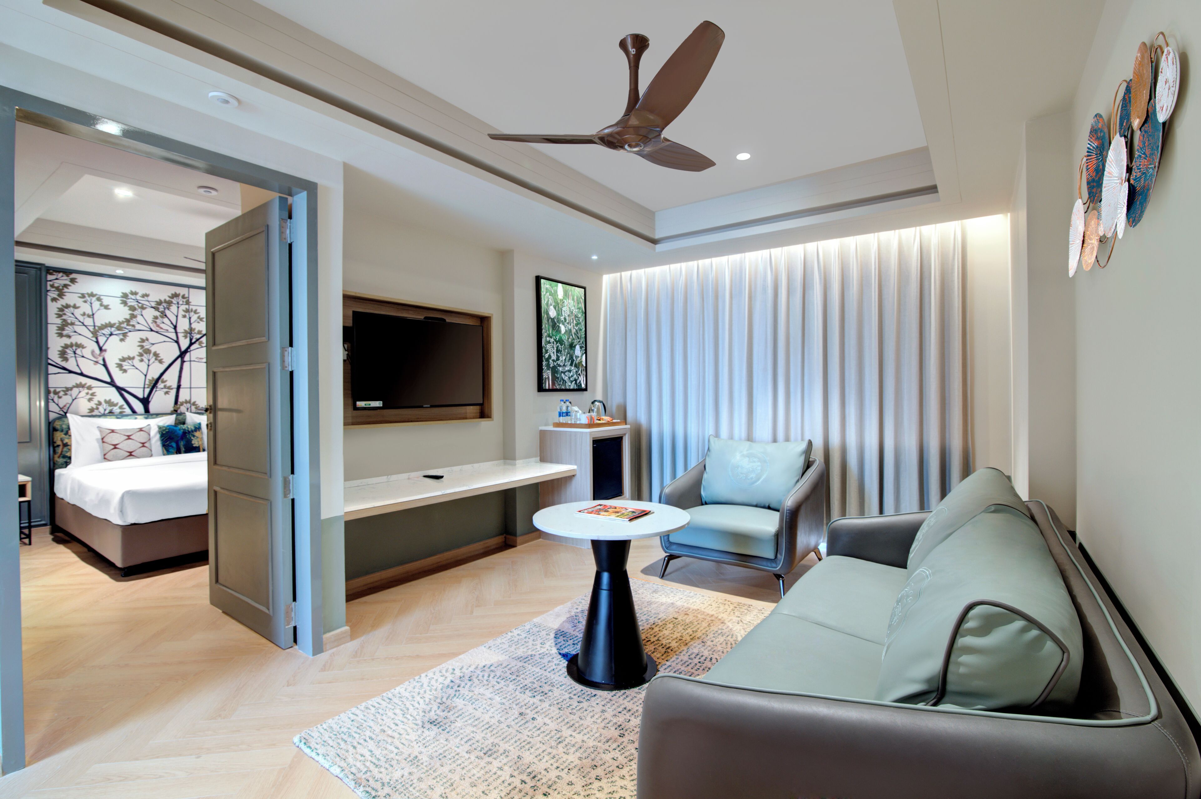 A modern living room with a sofa, a coffee table, a TV, and a ceiling fan.