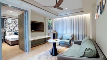 A modern living room with a sofa, a coffee table, a TV, and a ceiling fan.