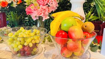 Dos recipientes de vidrio llenos de frutas y un florero con flores.
