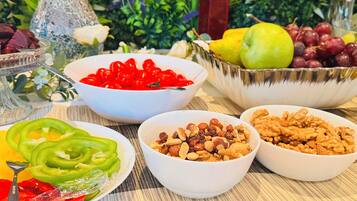 Una mesa con diversos alimentos, incluyendo tazones de nueces, uvas y verduras en rodajas.