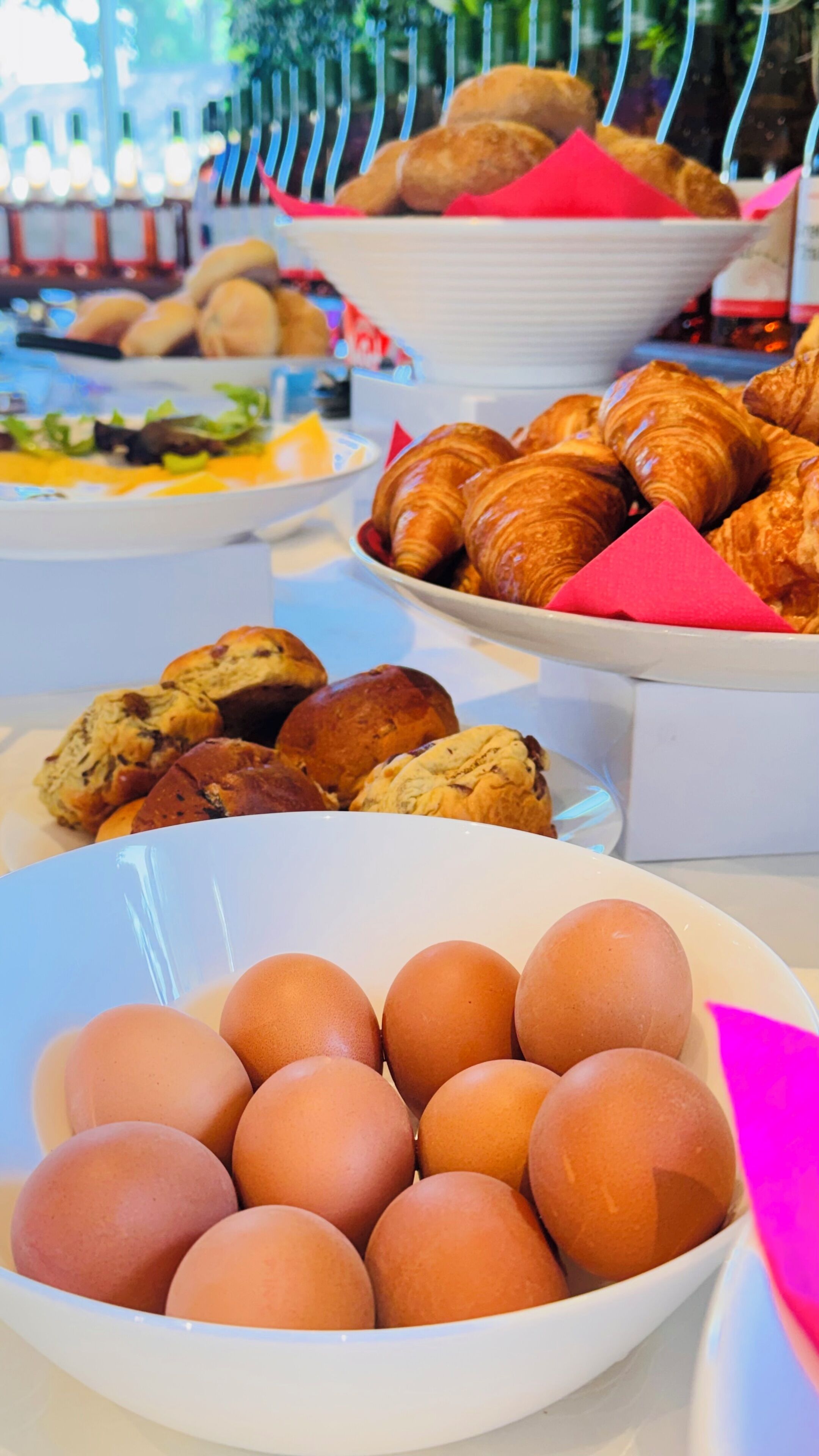 A buffet table with various food items including eggs, pastries, and sandwiches.
