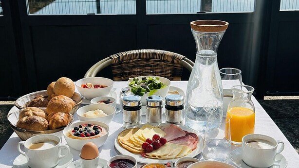 Una mesa de desayuno con diferentes alimentos y vista a un puerto deportivo.