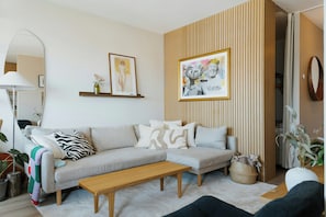 A living room with a sofa, a coffee table, a lamp, and a framed picture on the wall. - Panoramic views and sunsets atop Grünerløkka (Oslo)