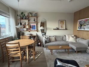 Ein Wohnzimmer mit einer Couch, einem Couchtisch und einem Essbereich mit Stühlen und einem Tisch.