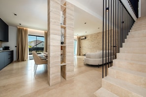 Ein modernes Interieur mit Treppe, Essbereich und Wohnzimmer.