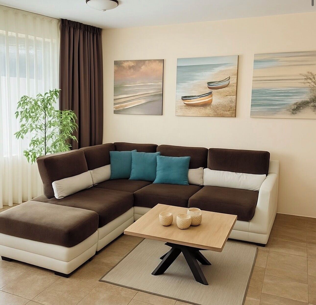 Un salon moderne avec un canapé d’angle, une table basse et trois tableaux accrochés au mur.