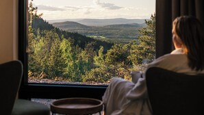 A room with a large window, two chairs, and a small table. - Kaamos Lodge (Ylitornio)