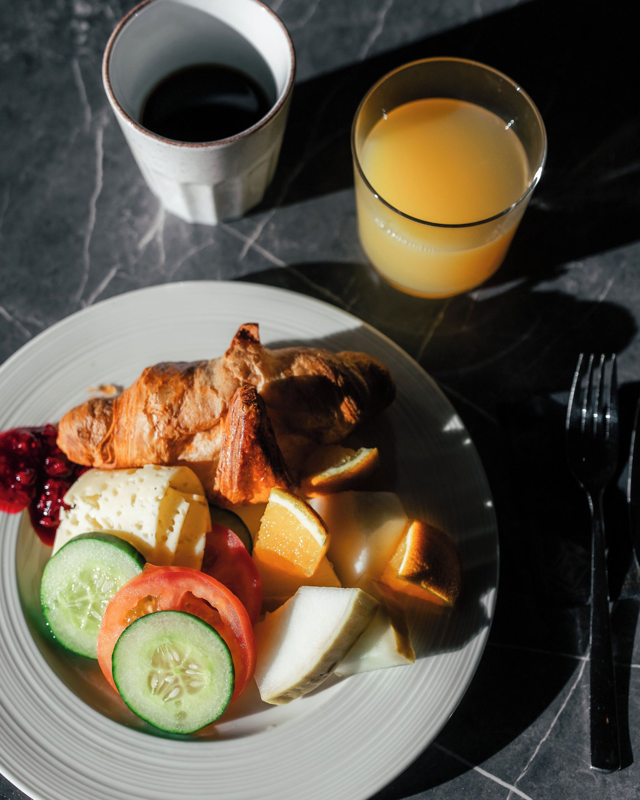 A plate with food and drinks on a table.