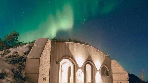 A building with arched windows and a snow-covered ground. - Kaamos Lodge (Ylitornio)