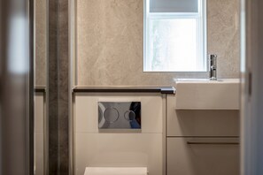 Ein Badezimmer mit Waschmaschine, Spiegel und Waschbecken.