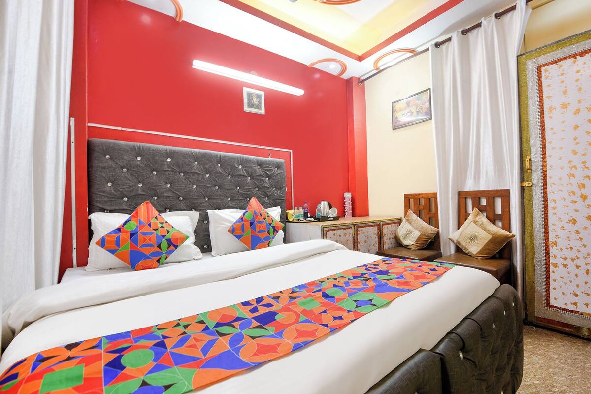 Una habitación de hotel con una cama, una mesita de noche, un escritorio y una silla.