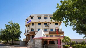A multi-story hotel with a prominent 'Tab Hotels' sign, a small entrance pavilion, and a staircase leading to the entrance. - Fabhotel Royal King (Ahmedabad)
