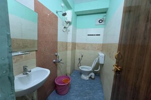A small bathroom with a sink, toilet, and shower.