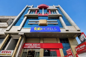 Un edifici amb un cartell de 'fabHOTELS', indicadors de 'HOTEL REGAL' i indicadors de 'REGAL BANQUET HALL'.