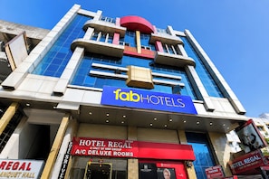 Hotellin julkisivu on moderni, ja siinä on suuri, huomiota herättävä kyltti, jossa lukee »Fab Hotels», sekä toinen kyltti, jossa lukee »Hotel Regal» ja joka osoittaa, että hotellissa on ilmastointi ja ylellisiä huoneita.