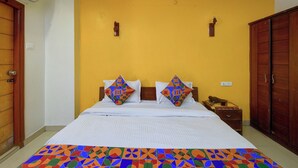 A hotel room with a bed, a wooden wardrobe, and a nightstand. - Fabhotel Regal I (Hyderabad)