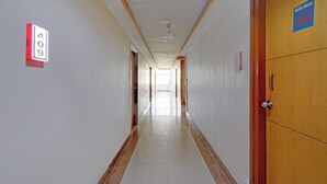 A hotel hallway with a wooden door marked '404' and a sign indicating room number 9. - Fabhotel Regal I (Hyderabad)