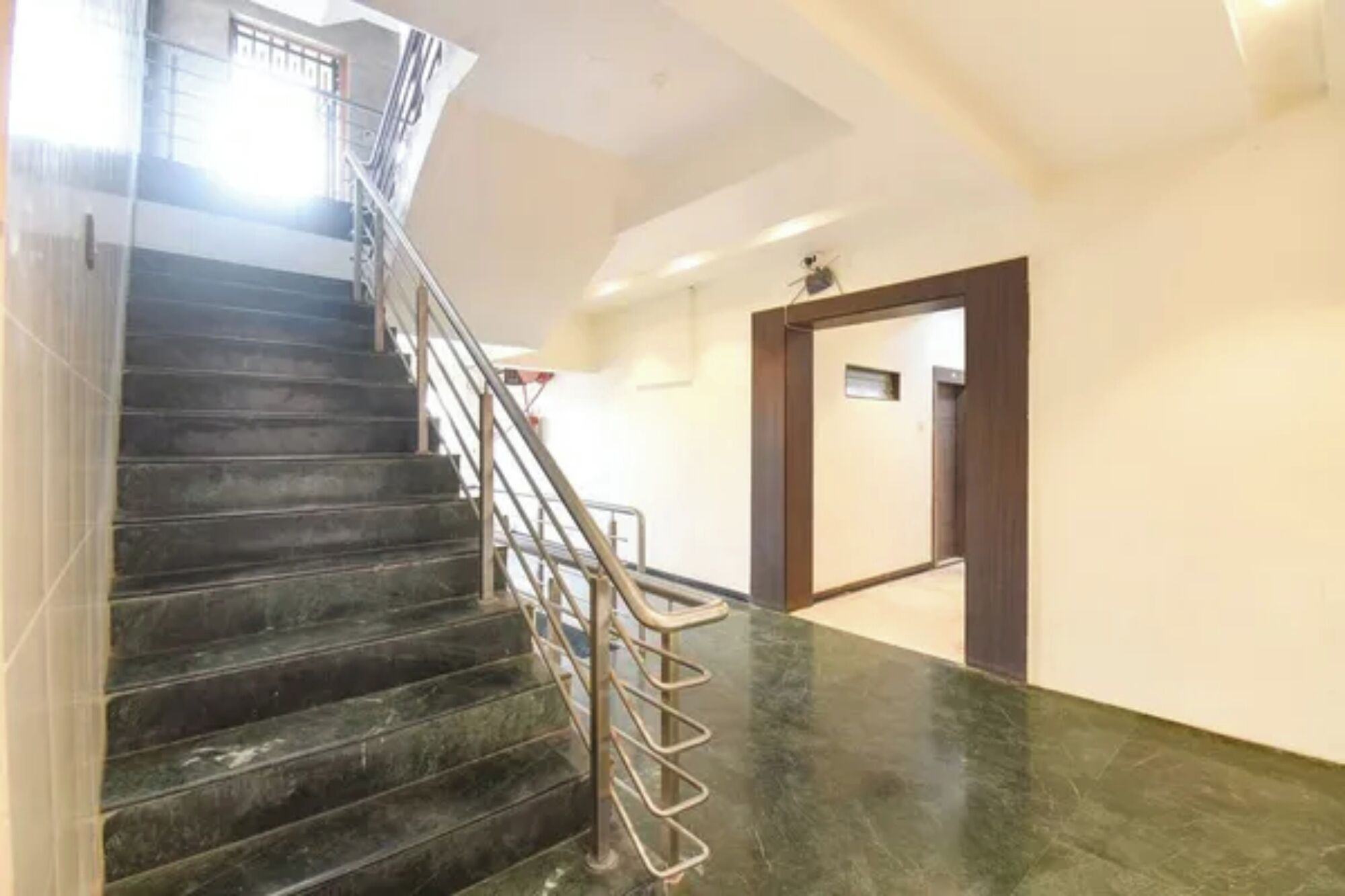 A staircase with metal railings leading to a landing.