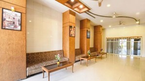 A lobby with a reception desk, seating area, and a large glass door entrance. - FabHotel New Rajdoot (Bhopal)