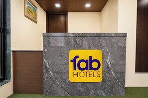 A reception desk with a marble top and a 'fab hotels' sign. - Via Nisarg Blue (Alibag)