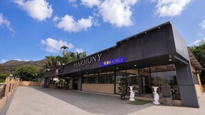 A Harmony Resort building with a modern facade, large glass windows, and a sign for FabHotels. - Fabhotel Prime Harmony Resort (Alibag)