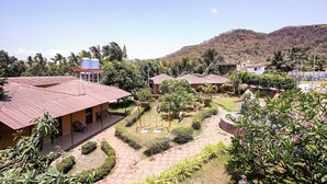 A courtyard with buildings, a playground, and a water tank. - Fabhotel Prime Harmony Resort (Alibag)