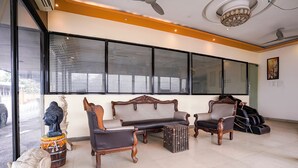 A room with a sofa, chairs, a decorative elephant, and a guitar. - Fabhotel Prime Harmony Resort (Alibag)