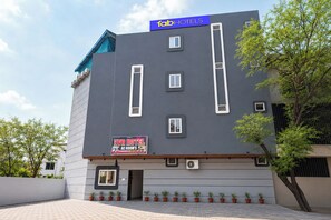 A modern building with a sign for 'fabHOTELS' and 'AVR HOTEL AC ROOM'S'. - FabHotel AVR, Mahalaxmi Nagar (Indore)