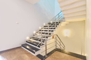 Una escalera con barandillas metálicas y escalones negros que conducen a una plataforma.