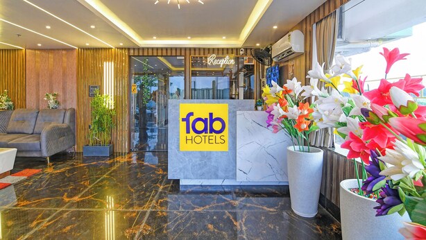 Ein Hotel-Empfangsbereich mit Marmorboden, einer Rezeption und einem modernen Kronleuchter.