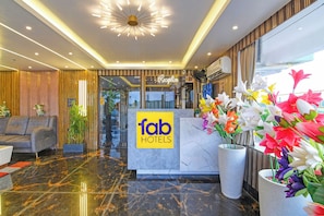 A hotel reception area with a marble floor, a reception desk, and a modern chandelier. - Fabhotel Prime Tanishq Inn (Barasat)