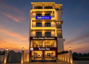 A multi-story hotel with a prominent 'fabHOTELS' sign, a 'Hotel & Family Restaurant' sign, and a 'JANISH JNN' logo. - FabHotel Prime Tanishq Inn (Barasat)
