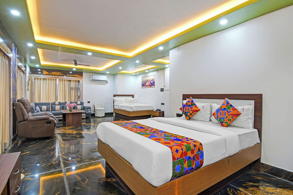 A hotel room with a bed, a sofa, a desk, and a chair.