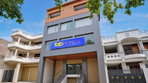 A modern hotel with a prominent sign, multiple balconies, and a staircase leading to the entrance. - FabHotel Southtown - Near Govindpuri Railway Junction (Kanpur)